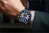 A man's wrist wearing a blue and gold watch. Produktbild-Vorschau
