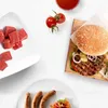 A collection of raw meat, cooked sausages, and a hamburger are arranged on a white surface, suggesting ingredients for a meal. Anteprima dell’immagine prodotto