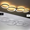 A split image showing a modern LED ceiling light. The top half shows the light on, illuminating a ceiling with a warm glow. The bottom half shows the light off, appearing as a white fixture against a white ceiling. Produktbild-Vorschau