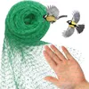 A hand is holding a green bird net, with two birds flying in the background. Produktbild-Vorschau