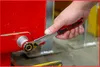 A hand is using a ratchet wrench to tighten a bolt on a red industrial machine. Náhled obrázku produktu
