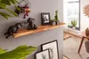 A wooden shelf with decorative elephant figurines and plants, in a room with a window and furniture. Anteprima dell’immagine prodotto