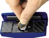 A hand is holding a coin over a blue sharpening tool with markings. Produktbild-Vorschau