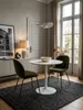 Moderner runder Esstisch in Weiß Hochglanz, elegant in Szene gesetzt in einem minimalistischen Esszimmer mit zwei grauen Samtstühlen und dezenter Dekoration._#sku_SAFWL6.504# Produktbild-Vorschau