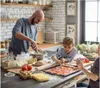 A father and his two sons are making pizza in a kitchen. Podgląd zdjęcia produktu