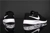 Two black Nike Tanjun sneakers are shown from different angles on a reflective black surface with water droplets. Podgląd zdjęcia produktu