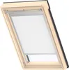 A close-up view of a VELUX skylight window with a white roller blind partially lowered. Produktbild-Vorschau