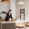 A woman is preparing food in a modern kitchen with a towel rack in the background. Produktbild-Vorschau