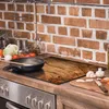 A kitchen counter with a stovetop, a cutting board, and various kitchen items. Produktbild-Vorschau