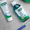 A tube of toothpaste and a bottle of mouthwash are placed on a marble surface. Náhľad obrázku produktu