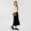A woman is posing with a small handbag. Anteprima dell’immagine prodotto
