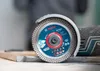 Close-up of a Bosch EXPERT diamond cutting disc on an angle grinder, positioned over a metal object. Produktbild-Vorschau