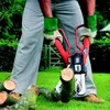 A person is using a Black & Decker chainsaw to cut a log in a grassy outdoor setting. Produktbild-Vorschau