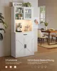A white sideboard with glass-fronted cabinets and drawers, featuring integrated lighting, is shown in a dining room setting. Produktbild-Vorschau