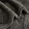 A close-up view of dark gray, fluffy fabric, likely a blanket. Produktbild-Vorschau