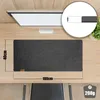 A desk mat is shown on a wooden desk, with a monitor in the background. Produktbild-Vorschau