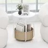 A round side table with a storage basket filled with books, placed near a window with sheer curtains. Anteprima dell’immagine prodotto