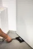 A hand is using an inflatable lifting cushion to create a gap under a door. Produktbild-Vorschau