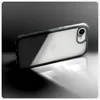 A clear phone case with a phone inside, placed on a reflective surface with dramatic lighting. Voir les images du produit