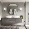 A modern bathroom with a double vanity, round mirror, and shower. Podgląd zdjęcia produktu