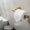 A toilet paper holder with a roll of toilet paper mounted on a tiled wall. Produktbild-Vorschau