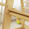 A close-up view of the wooden construction of a children's climbing frame, showing the joinery and texture of the wood. Podgląd zdjęcia produktu