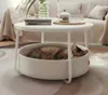 A cat sleeping in a pet bed integrated into a round coffee table in a living room setting. Produktbild-Vorschau