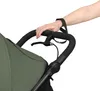 A close-up shot of a person's hand holding the handle of a stroller. Náhled obrázku produktu