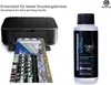 A printer is shown printing a document, next to a bottle of printer cleaning fluid. Produktbild-Vorschau