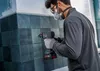 A person is drilling into a tiled wall. Podgląd zdjęcia produktu