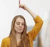 A woman is using a head massager. Náhľad obrázku produktu