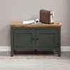 A dark green cabinet with a wooden top, a magazine, and a brown bag on top, placed on a striped rug. Anteprima dell’immagine prodotto