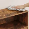 A hand is wiping a wooden shelf with a cloth, showing water droplets on the surface. Produktbild-Vorschau