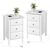 Two white nightstands with built-in charging ports and USB ports, each topped with a small potted plant and a smartphone. Podgląd zdjęcia produktu