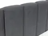 A close-up view of a dark gray upholstered headboard with vertical channel tufting. Náhled obrázku produktu