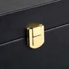 A close-up of a black box with a gold latch. Produktbild-Vorschau