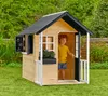 A young boy stands in a wooden playhouse in a garden. Náhled obrázku produktu