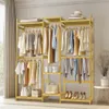 A wooden clothing rack with multiple shelves and hanging rods, filled with various clothing items, bags, and shoes. Produktbild-Vorschau