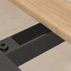 A close-up view of the connection between a wooden surface and a black metal frame, with a piece of black velcro attached to the frame. Anteprima dell’immagine prodotto