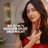 A woman is holding a small red bottle in front of a mirror with decorative lights. Anteprima dell’immagine prodotto