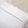 A close-up view of a white plastic slide with embossed stars. Náhled obrázku produktu