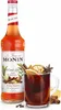 A bottle of Monin Winter Spice syrup stands next to a mug of mulled wine, garnished with fruit and spices. Podgląd zdjęcia produktu