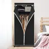 A black fabric wardrobe with clothes hanging inside is shown, with a bed in the background. Podgląd zdjęcia produktu