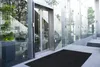 Entrance to a modern building with glass facade and automatic doors. Produktbild-Vorschau