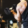 A person is holding a dumbbell in a gym. Anteprima dell’immagine prodotto