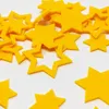 A pile of yellow felt star-shaped cutouts scattered on a white surface. Produktbild-Vorschau