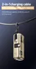 A gold-colored mini power bank with a lanyard is hanging from a black cable against a dark blue background. Produktbild-Vorschau