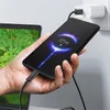 A hand is holding a smartphone that is charging, connected to a laptop. Produktbild-Vorschau