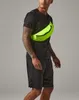 A man wearing a black t-shirt and shorts, with a neon green fanny pack across his chest. Anteprima dell’immagine prodotto
