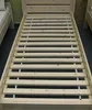 A close-up view of a wooden bed frame with slats. Produktbild-Vorschau